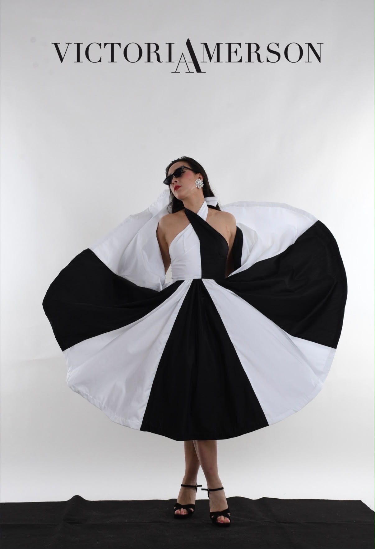 Victoria Amerson presenting a black and white circle skirt dress at a Victoria Amerson Design showcase