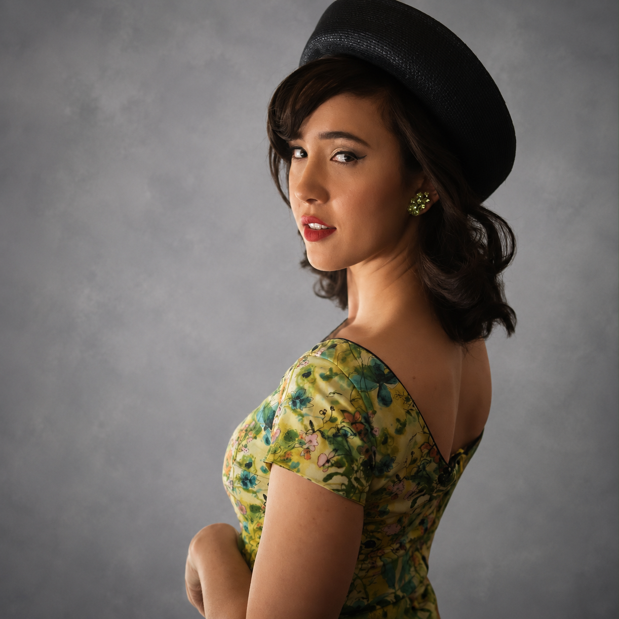 Editorial portrait of Victoria Amerson in a black hat and floral 1950s style dress